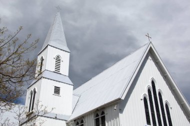 Akaroa tatil beldesindeki (Yeni Zelanda) ahşap Presbiteryen Kilisesi üzerindeki koyu ağır bulutlar).
