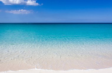 Cennet Adası 'ndaki (Bahamalar) güneşli turkuaz renkli kumsal sularının manzarası).