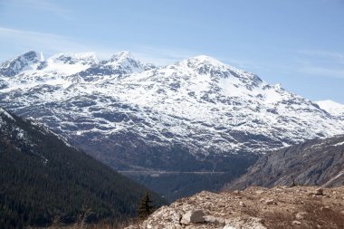 Beyaz Geçitten geçen trenin manzarası Sahil Dağları 'nın Sınır Dağları' ndan 873 metre yüksekliğe ulaşır (Alaska).