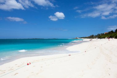 The scenic view of the wide sandy beach and a colorful sea on Paradise Island (Bahamas).