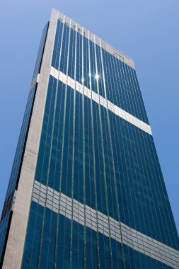 The view of a tall glass covered skyscraper with sunlight reflections in Sydney downtown (New South Wales).
