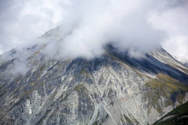 The scenic view of a mountain peak surrounded by clouds in Glacier Bay national park (Alaska).