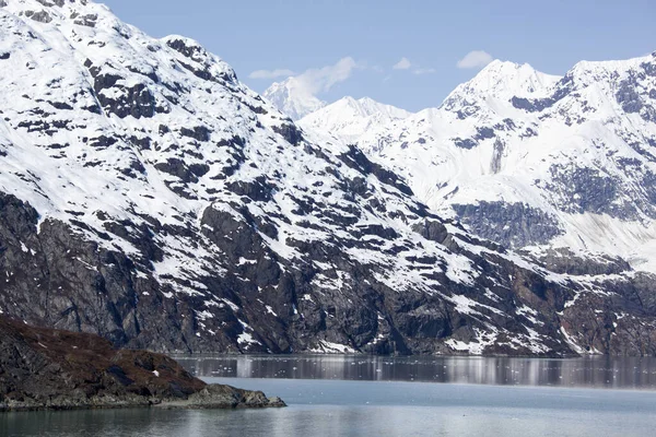 Der Frühlingsblick Auf Die Steilküste Und Die Verschneiten Berge Glacier Stockbild