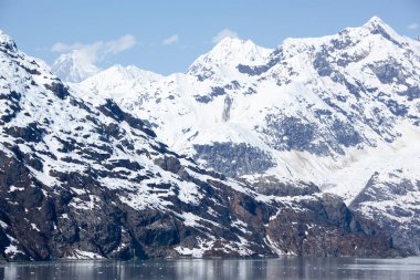 The scenic view of mountains covered by snow on May in Glacier Bay national park (Alaska).