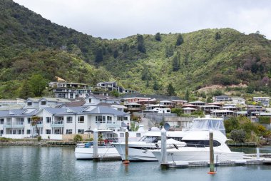 The view of marina and residential district with green mountains behind in Picton resort town (New Zealand).