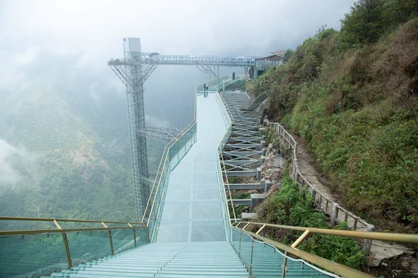 在越南 一座透明的玻璃桥矗立在海拔2333米的地方 鸟瞰着多云的风景 免版税图库图片