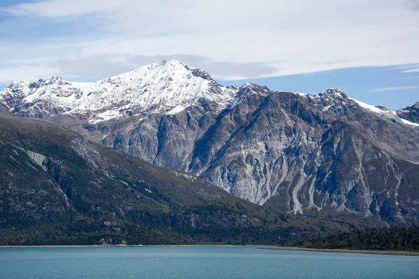 Buzul Körfezi Ulusal Parkı 'nda (Alaska) sonbaharın başlarında tepesinde kar olan yüksek bir dağın manzarası).