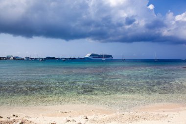 Büyük Cayman Adası 'ndaki George Town yakınlarında yağmur bulutları altında sürüklenen bir yolcu gemisinin görüntüsü (Cayman Adaları)).