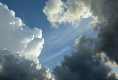 Kontrastlı koyu renkli yağmur bulutları (Litvanya) tarafından çerçevelenmiş mavi gökyüzünün soyut görüntüsü).