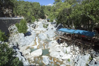 Antalya 'nın Kesme Bogazi Kanyon Parkı' nda (Türkiye) sığ bir dere üzerine inşa edilmiş ahşap bir restoranın sabah manzarası).