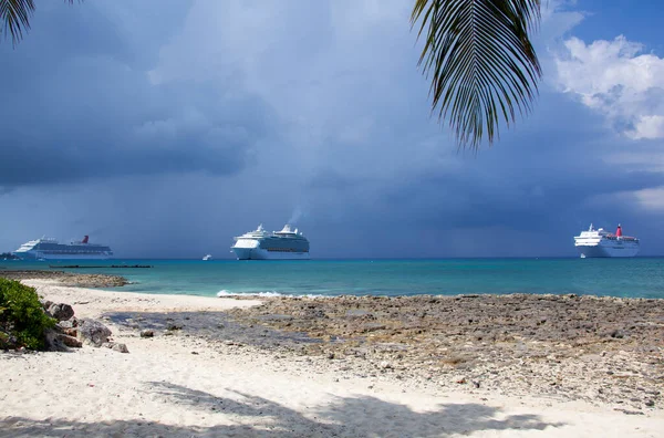 Büyük Cayman adasının manzarası Seven Mile Beach ve arka planda üç yolcu gemisi (Cayman Adaları)).