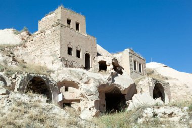 Kapadokya bölgesindeki Cavusin köyünde (Türkiye) tek bir yerleşim yeri olarak inşa edilen ev ve mağara manzarası).