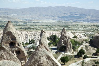Uchisar 'ın hava manzarası mağaralarla kayaları aşındırdı ve arka planda bir vadi (Kapadokya, Türkiye).