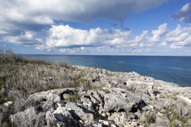 Karayip Denizi üzerindeki bulutlu gökyüzü manzarası ve Küçük Stirrup Koyu 'ndaki kayalık kıyı şeridi (Bahamalar)).