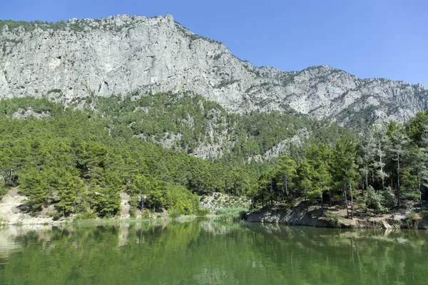 Antalya ilinin (Türkiye) arkasında dik bir dağ bulunan yeşil renkli Karacaoren Gölü manzarası).