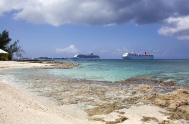Yedi Mil Sahili manzarası ve Cayman Adaları 'ndaki Büyük Cayman Adası' nda George Town yakınlarında sürüklenen iki yolcu gemisi.).