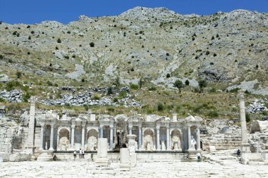 Sagalassos antik şehir çeşmesinin, akan kaynak suyu ve arkasında bir dağ manzarası (Türkiye)).