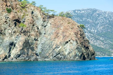 Antalya 'nın (Türkiye) arka planında Adrasan turizm kasabasıyla dik kayalık kıyı şeridinin manzarası).