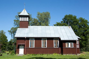 Küçük bir köyde (Litvanya) tahta bir katolik kilisesinin yaz manzarası).