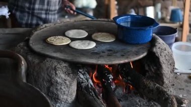 Meksikalı kadın geleneksel bir şekilde mısır tortillası yapıyor.