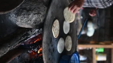 Meksikalı kadın geleneksel bir şekilde mısır tortillası yapıyor.)