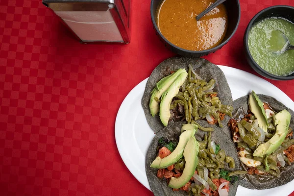 Otantik Meksika tacoları yanında kırmızı ve yeşil sos.