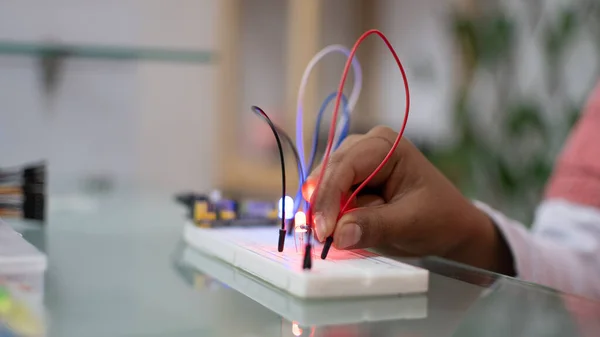 Child\'s hand making electrical connections to turn on led lights