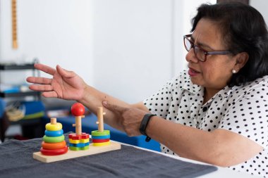 Kadın fizyoterapide eklem iltihabı tedavisi için güç aleti kullanıyor