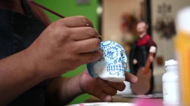 Meksikalı bir zanaatkar bir alebrije kafatası çizmiş.