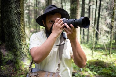 Genç Meksikalı adam telefoto lensleriyle fotoğraf çekiyor.