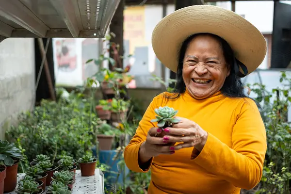 Bahçesiyle ilgilenirken gülümseyen Meksikalı kadın.