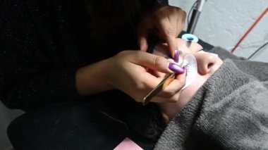 Yapay kirpik takan bir güzellik uzmanı.