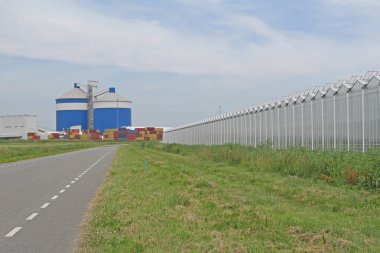 Hollanda 'nın kırsal kesimlerinde büyük bir sera kompleksi, siloları ve konteynır terminalleri olan bir iş alanı.