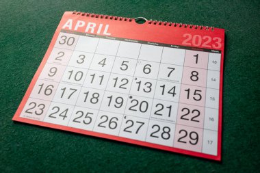 Takvim 2023, Nisan, aylık planlamacı. Gün, ay, yıl, tarih ve etkinlik düzenleyici duvar ve masa planlayıcısı. Kırmızı ve beyaz takvimde büyük harfler ve yeşil arkaplan numaraları var. Açıyla gösterilen.