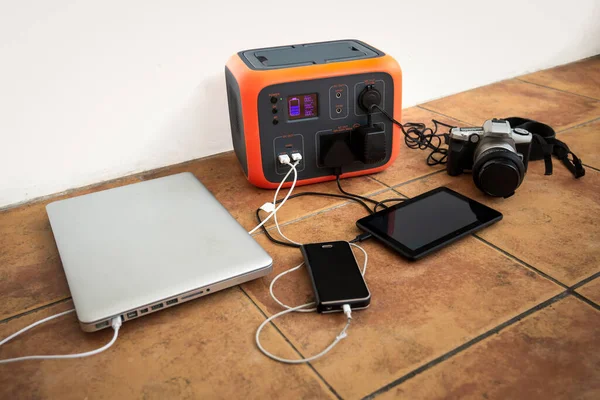 Taşınabilir elektrik santrali güneş enerjisi jeneratörü - laptop, telefon, tablet ve dijital kamera elektronik cihazları şarj ediliyor. Kablosuz şarj pili, elektrik kesintisi açık havada acil durum, kamp.