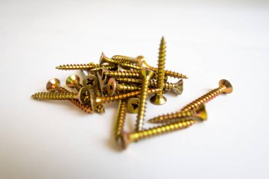 Orta büyüklükteki sarı vidalar DIY ev geliştirme ve inşaat işleri için kapanıyor. Beyaz arka planda izole edilmiş. Araç kutusu ekipmanlarının temel parçası.