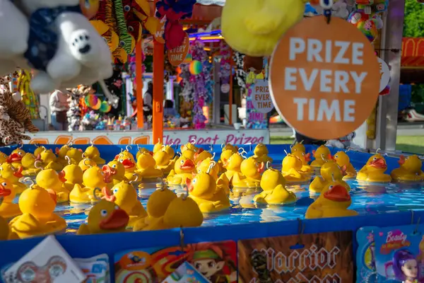 Canterbury, İngiltere, 28 Mayıs 2023: Sarı plastik ördekler 28 Mayıs 2023 'te Canterbury İngiltere' deki British Funfair festival standında ördek havuzunda yüzüyorlar. Kazanacak ödüllerle çevrili.