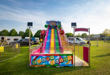 Canterbury, İngiltere, 28 Mayıs 2023: 28 Mayıs 2023 'te Canterbury İngiltere' de düzenlenen geleneksel İngiliz lunaparkında çok renkli plastik kaydırak. Çocuklar ve yetişkinler için hızlı eğlence ve heyecan verici aile eğlencesi