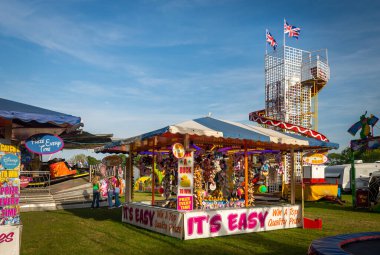 Canterbury, İngiltere, 28 Mayıs 2023: 28 Mayıs 2023 'te Canterbury İngiltere' deki lunaparkın güneşli bir gününde İngiliz panayır fuarında ödül standları, oyunlar, vals yarışları ve yardımcı kaydırak sürüşleri ile İngiliz panayırı festivali. 