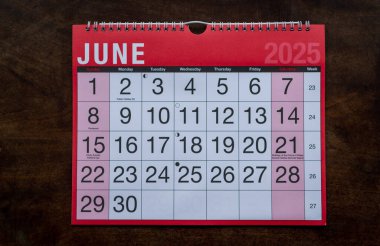 Takvim 2025, Haziran, aylık planlamacı. Gün, ay, yıl, tarih ve etkinlik düzenleyici duvar ve masa planlayıcısı. Ahşap zemin üzerinde büyük harfler ve rakamlar olan kırmızı ve beyaz takvim. 