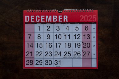 Takvim 2025, Aralık, aylık planlamacı. Gün, ay, yıl, tarih ve etkinlik düzenleyici duvar ve masa planlayıcısı. Ahşap zemin üzerinde büyük harfler ve rakamlar olan kırmızı ve beyaz takvim. 