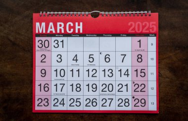 Takvim 2025, Mart, aylık planlamacı. Gün, ay, yıl, tarih ve etkinlik düzenleyici duvar ve masa planlayıcısı. Ahşap zemin üzerinde büyük harfler ve rakamlar olan kırmızı ve beyaz takvim. 