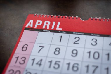 Takvim 2025, Nisan, aylık planlamacı. Gün, ay, yıl, tarih ve etkinlik düzenleyici duvar ve masa planlayıcısı. Ahşap zemin üzerinde büyük harfler ve rakamlar olan kırmızı ve beyaz takvim. 