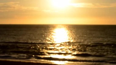 Arka plan bulanık. Güneş gün batımında gökyüzünde parlıyor. Gün doğumunda gün batımında. Güneşli yol, deniz dalgalarının yüzeyinde güneşli yürüyüş yolu. Güneş ışığı. Deniz manzarası. Doğal bulanık bokeh dokusu