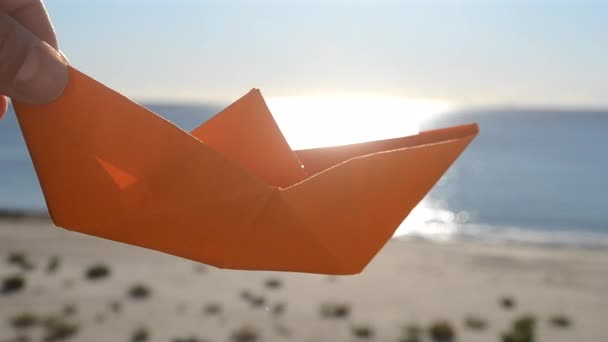 Osoba Držící Ruce Oranžový Papírový Člun Pozadí Modré Oblohy Písečné — Stock video