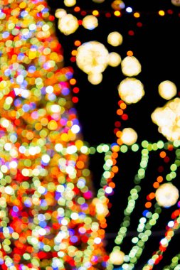 New Years Christmas tree decorated with luminous multi-colored garlands and illumination at night. Christmas tree with flashing lights. Blurred background. New Year Christmas holidays.