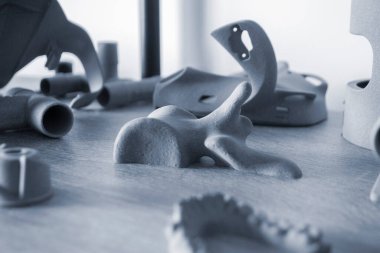 Toz 3D yazıcıya yakın planda basılmış insan kemiğinin prototip parçası. Polyamide tozundan üç boyutlu yazıcıya basılmış figür. Çoklu Jet Füzyon MJF. Yeni katkı maddesi modern 3D yazıcı teknolojisi