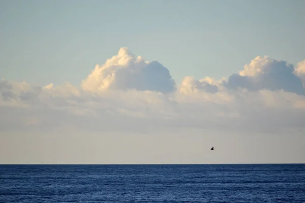 Λευκά Πυκνά Σύννεφα Πάνω Από Την Μπλε Επιφάνεια Της Θάλασσας — Φωτογραφία Αρχείου