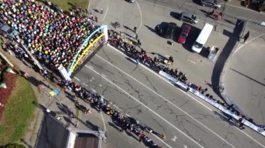 Bila Tserkva, Ukrayna, 10 Ekim 2021: Pek çok erkek ve kadın finiş çizgisinden koşarak şehir koşusu yarışmalarına katılmaya başladı. Sporcular yarışıyor. Hava aracı görüntüsü. Üst görünüm