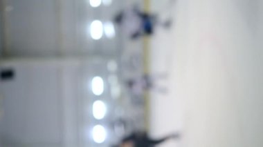 Arka plan bulanık. Hokey oynayan hokey oyuncuları. Çocuklar buz pateni pistinde hokey oynuyorlar. Buz hokeyi şampiyonası spor buz pateni yarışmaları Gerçek profesyonel video oyunu